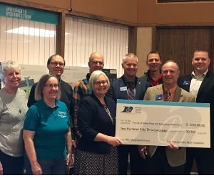 Photo of team members holding a large check