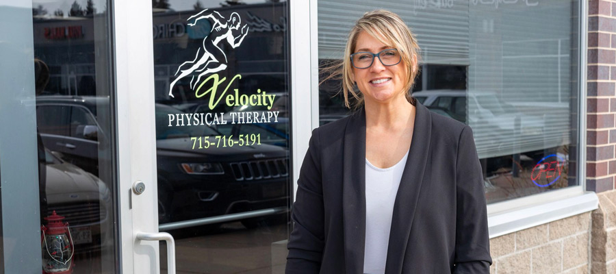 Photo of a business woman standing in front of her store