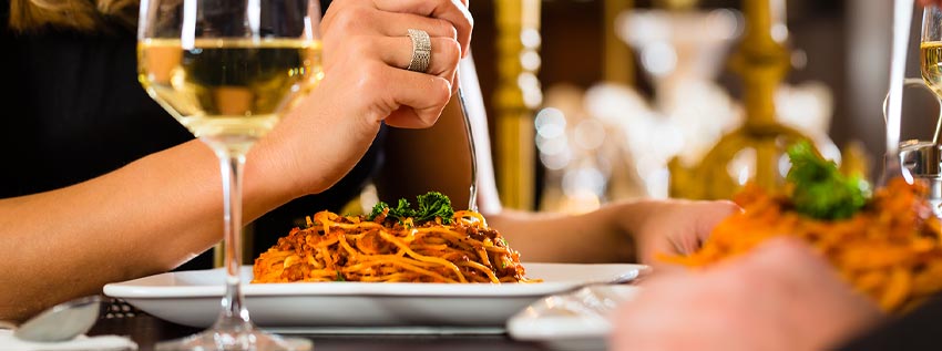 Woman eating pasta in a restaurant