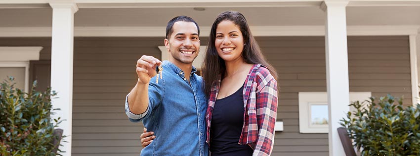 Young couple holding keys of new home