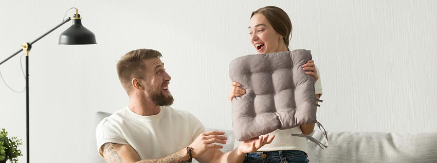 Couple unpacking seat cushion in home