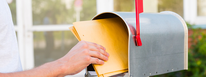 Person putting mail in mailbox