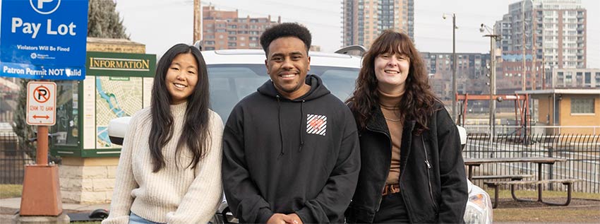 College kids sitting in front of car