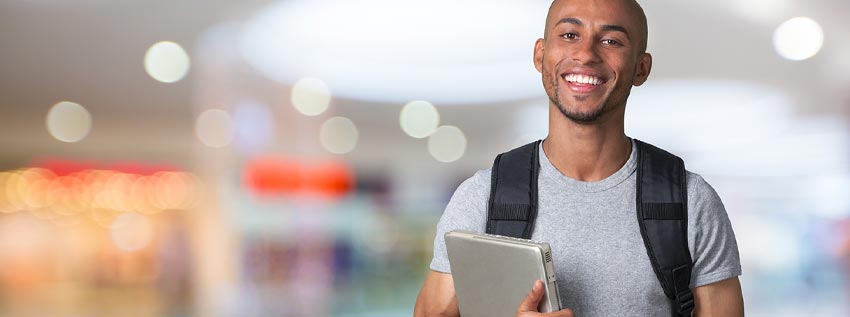 College grad holding laptop