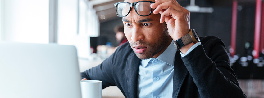 Frustrated man looking at his laptop