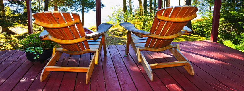 Two chairs at a cabin facing the lake