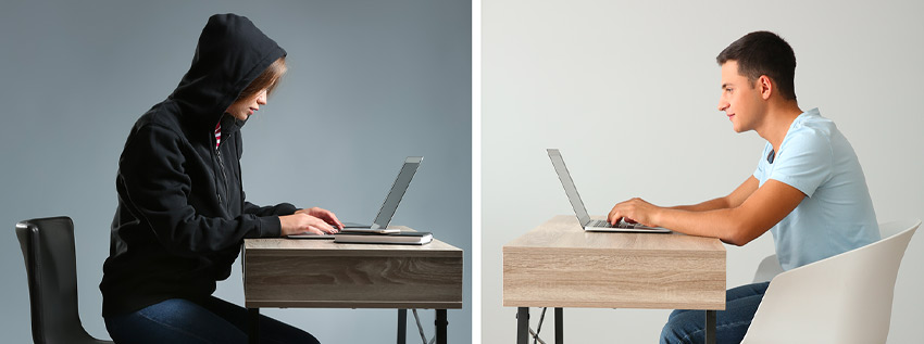 Two students on their computers facing each other