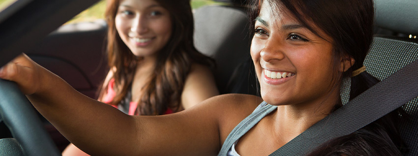 Two teenagers driving in a car