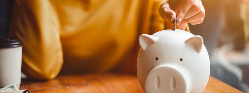 Woman putting money into a piggy bank