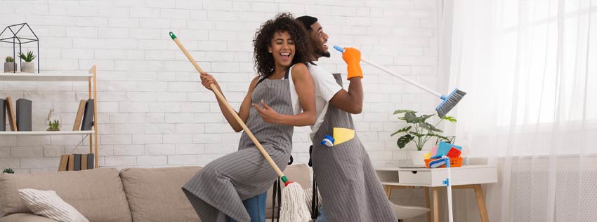 young couple having fun while spring cleaning