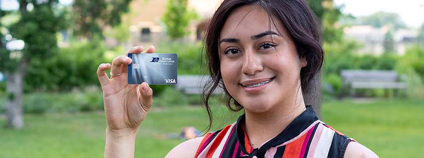 Young woman holding a Royal Rewards Visa card