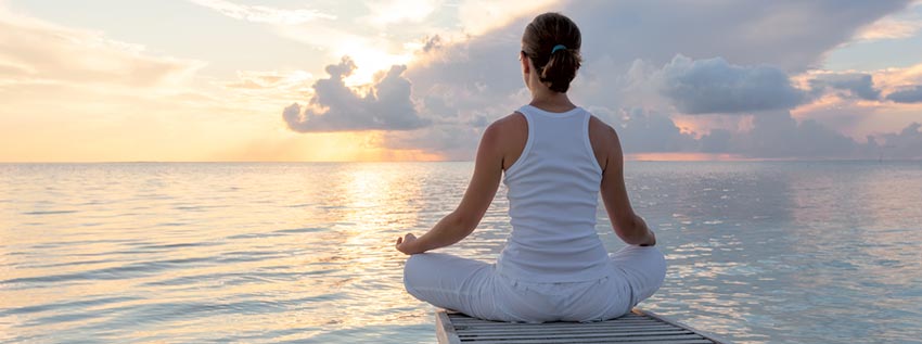 Woman doing yoga on a dock