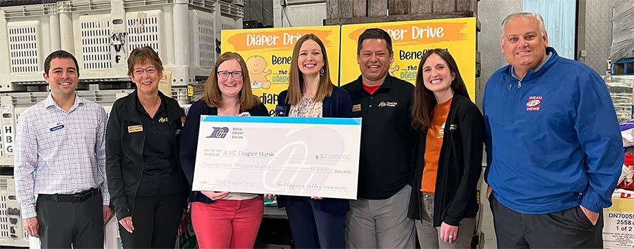 People at Diaper Drive event holding a big check