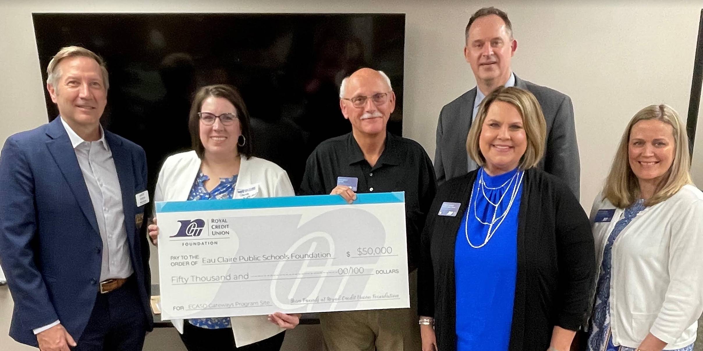 Team members holding a large check
