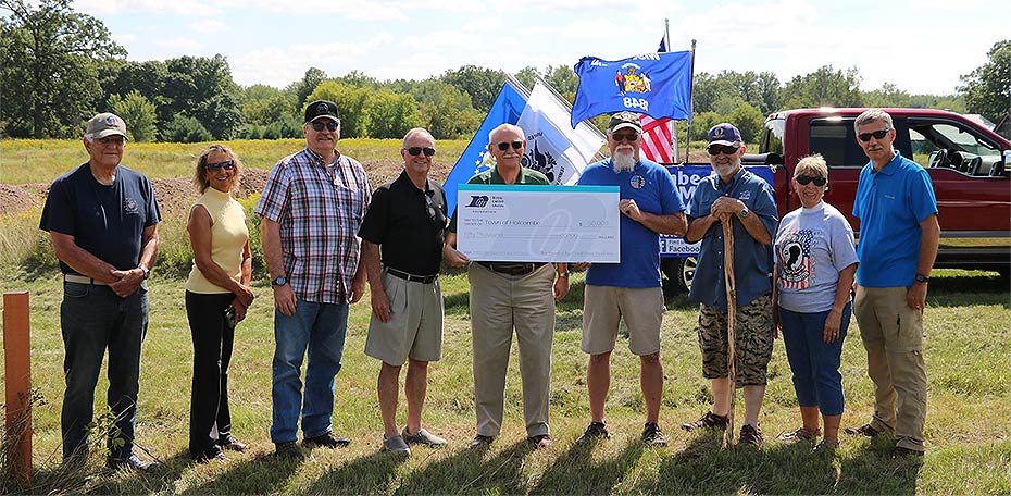 Photo of team holding a large check