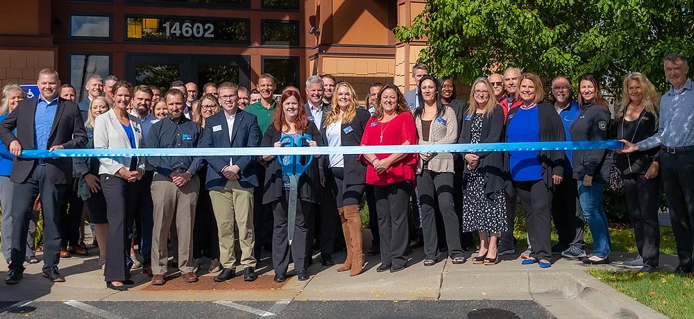 Team member at Hugo doing a ribbon cutting