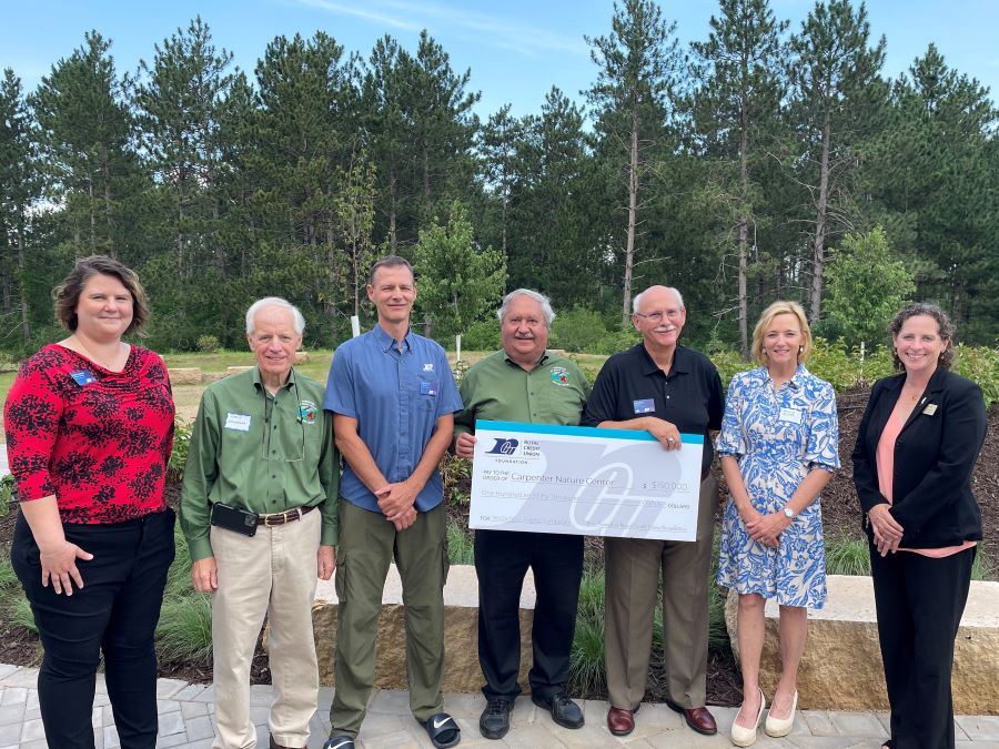 Team of folks standing with a big check