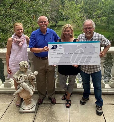 Photo of group of people holding a big check