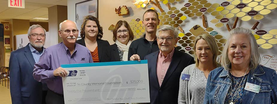 Group of people holding a large check at the clinic