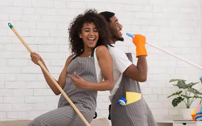 young couple having fun while spring cleaning