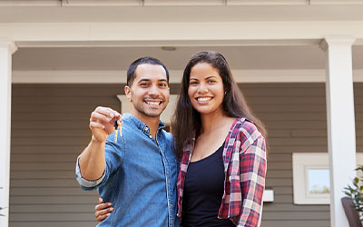 Couple standing in front of house