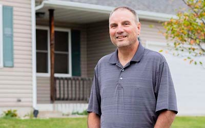 Man standing in front of his home