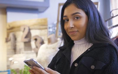 Woman looking at her mobile phone and making a transfer