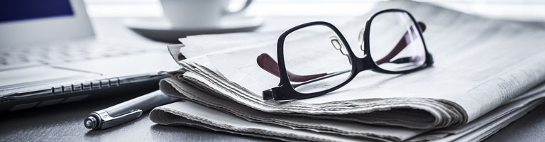 Glasses, computer and newspaper