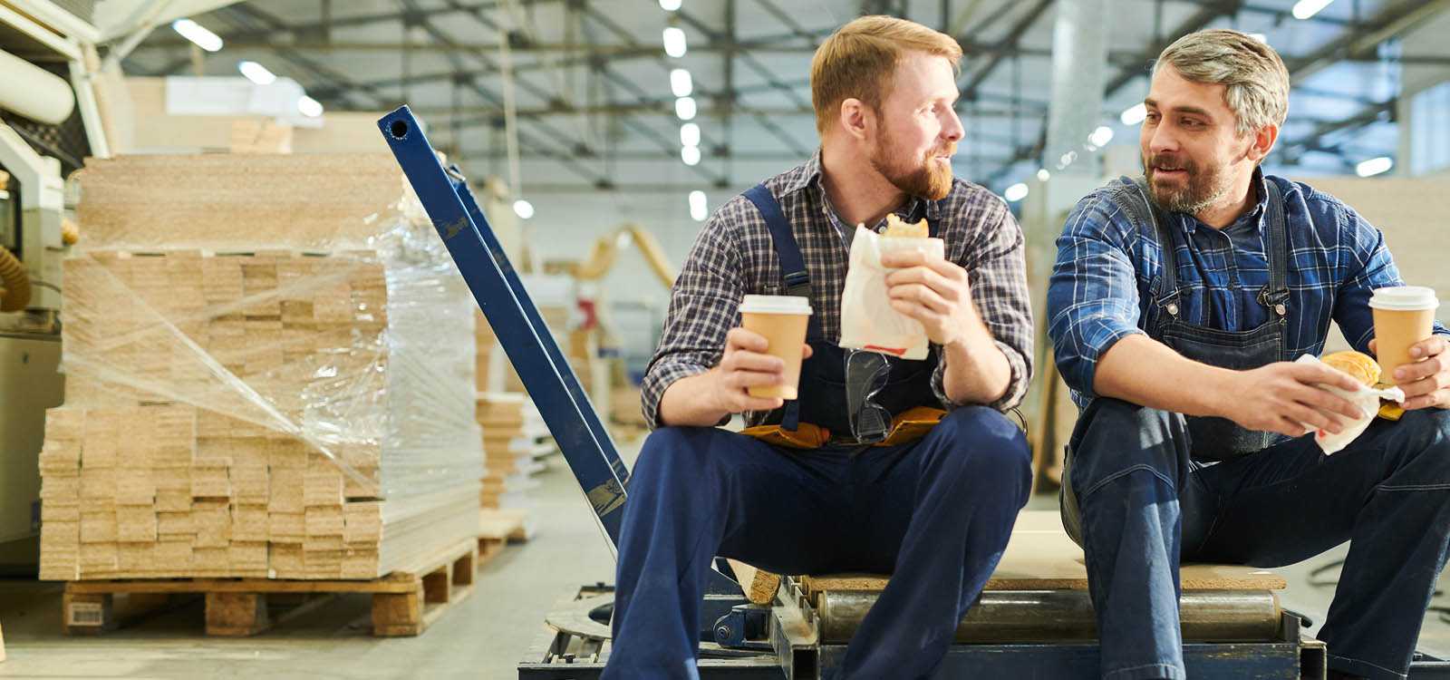 two men in warehouse eating