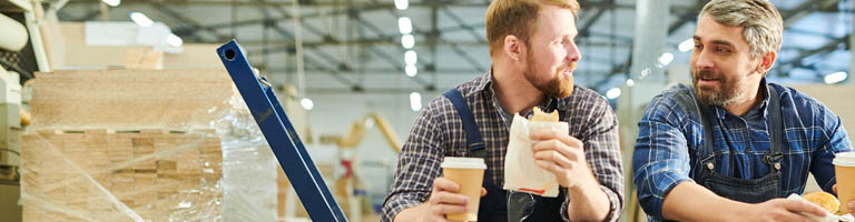 two men in warehouse eating