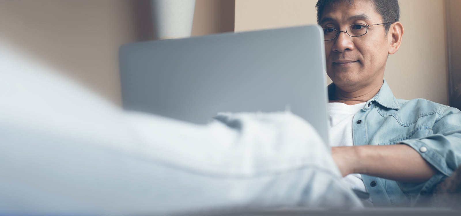 man with glasses looking at a laptop screen