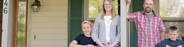 happy family on porch of new home