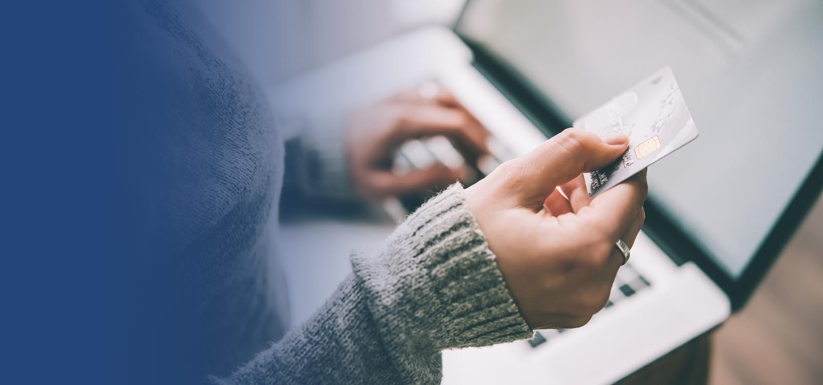 Person looking at debit card and computer