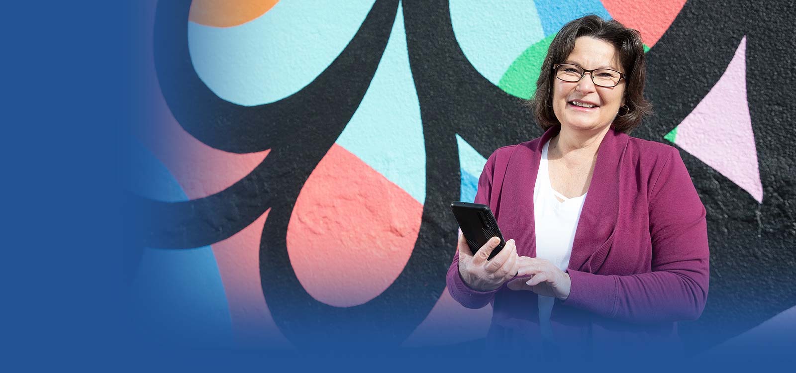 Woman in front of building on her phone