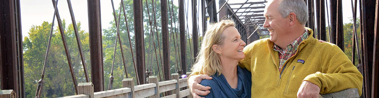 older man and woman on a bridge