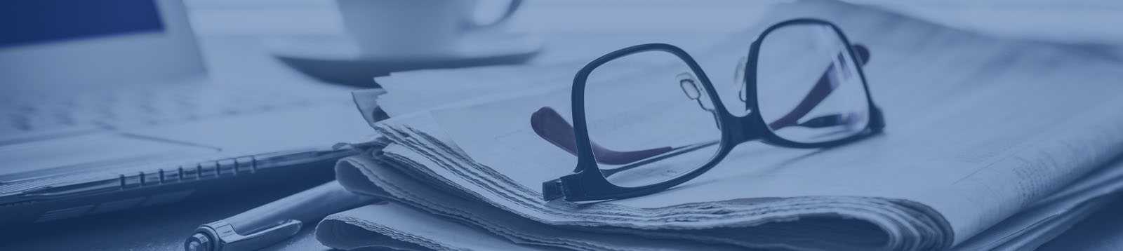 Glasses, computer and newspaper