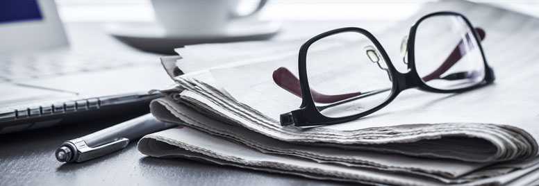 Glasses, computer and newspaper