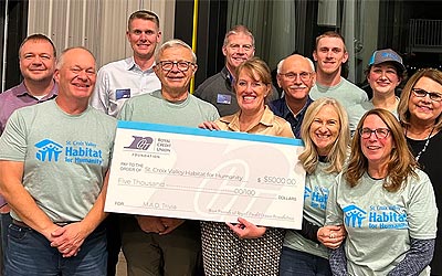 Photo of people holding a big check at the M.A.D. Trivia event
