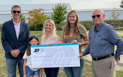 Foundation members and Fairyland members holding a large check