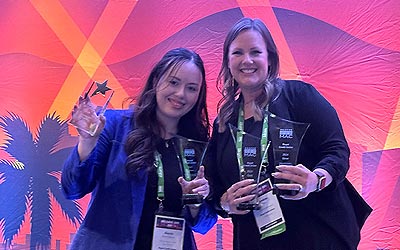 Marketing team holding awards at the event