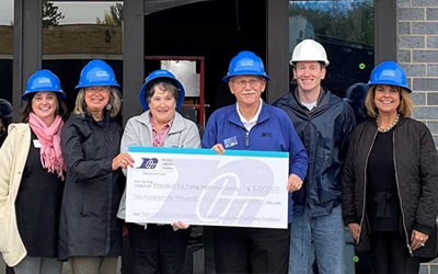 Group of community leaders holding a big check