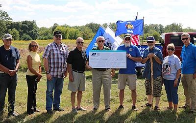 Photo of team holding a large check