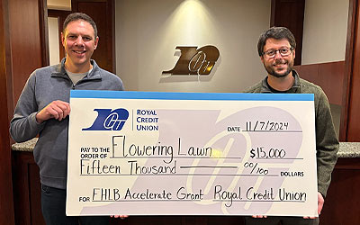 Two business people holding a large check
