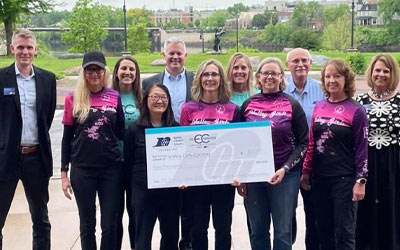 Photo of group holding a big check