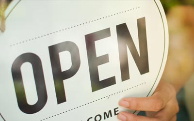 Small business owner with an open sign