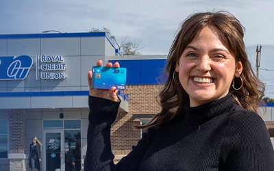 Member holding a debit card in front of an Office