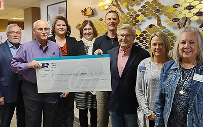Group of people holding a large check at the clinic