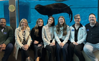 Group of people sitting in front of sea lion at the MN Zoo