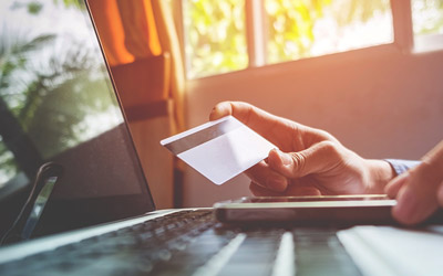 Person holding credit card and laptop