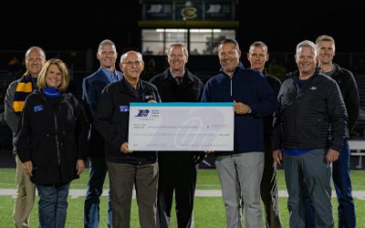 Group of leaders holding a large check